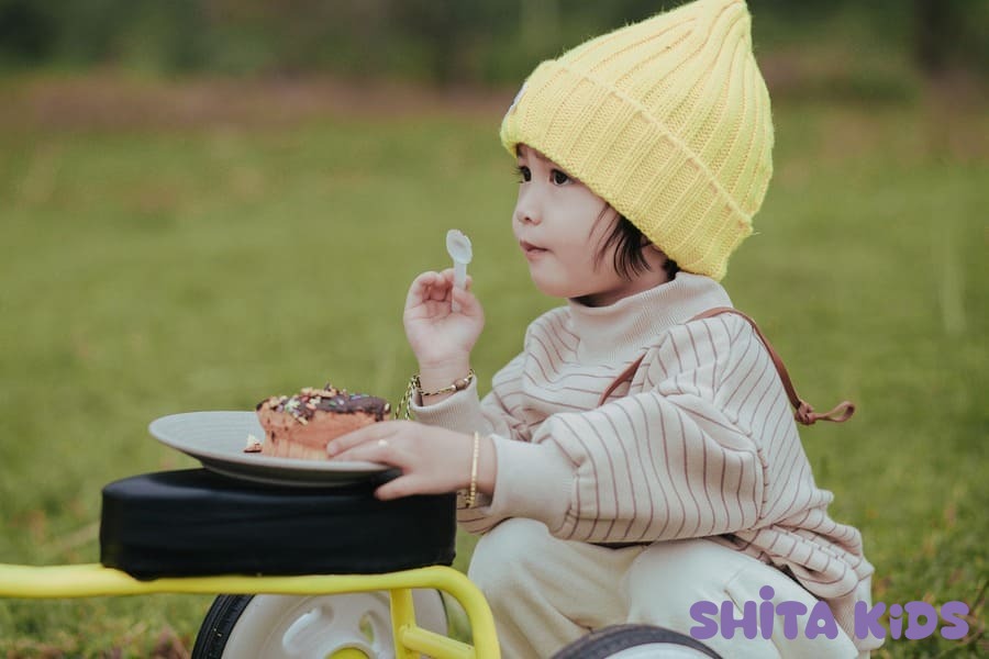 Bé tự cầm thìa ăn dặm ngoài trời, dấu hiệu bé no sau 6 tháng